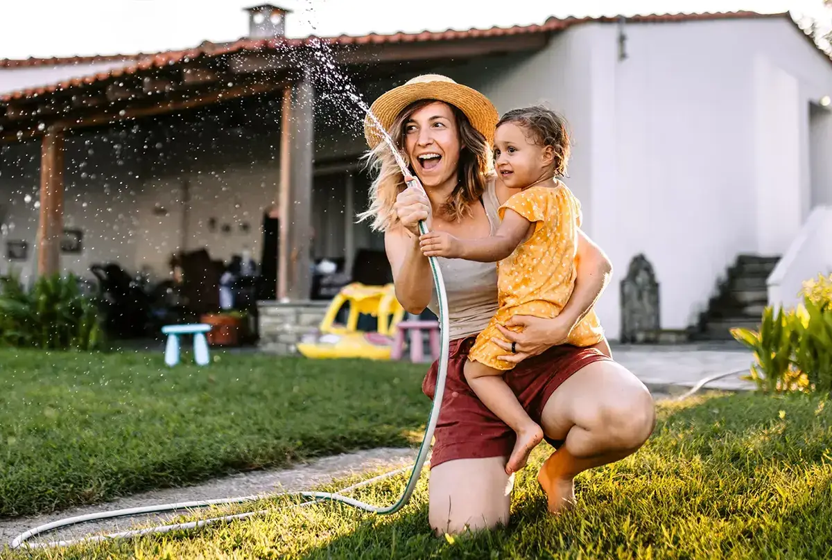 Happy mom and child in front of home
